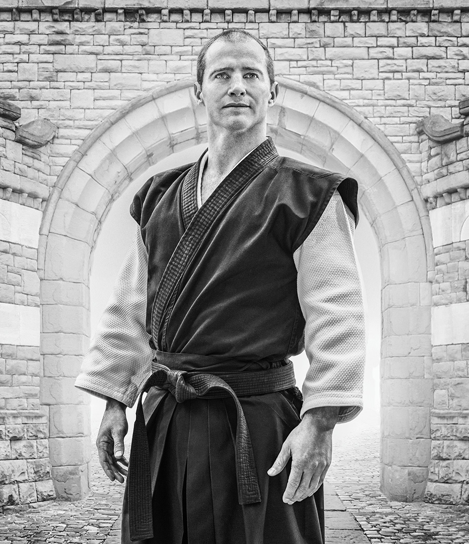 B/W photographic portrait of male black belt ju jitsu fighter i full reglia